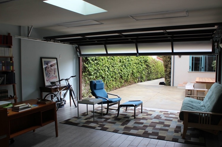Garage renovated into office space with partially open glass garage door