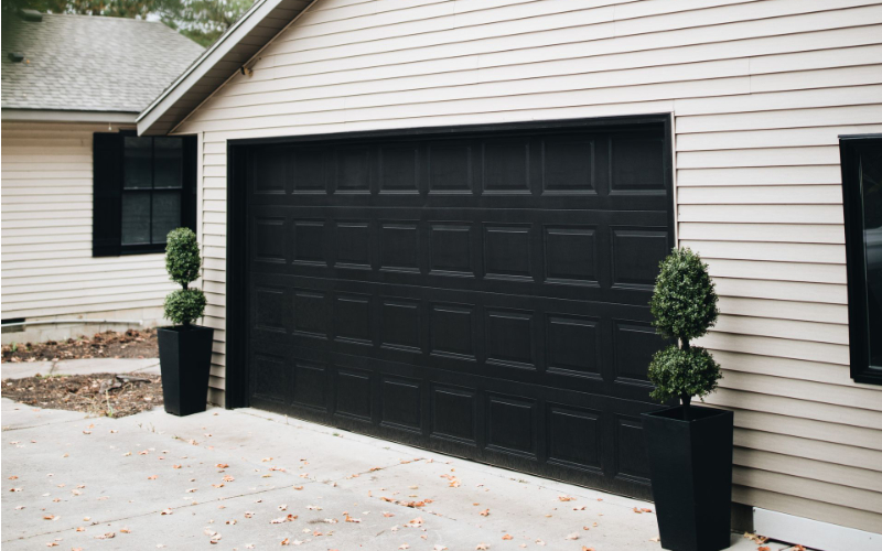 Black garage door on white exterior home