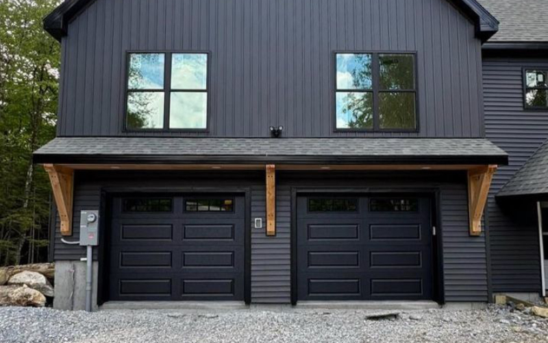 Black garage door with minimalist landscaping