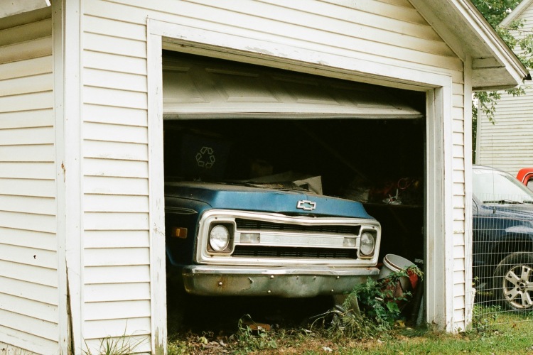 Detached one-car garage in backyard with bent garage door panels