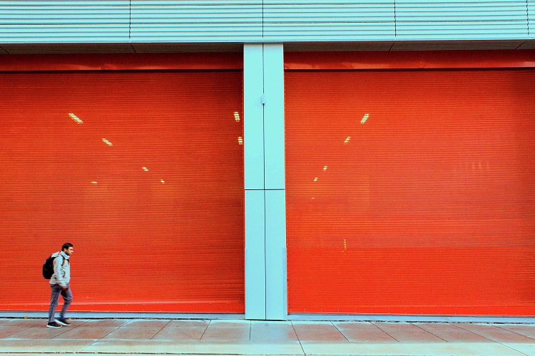 Large red overhead doors at storefront of commercial building