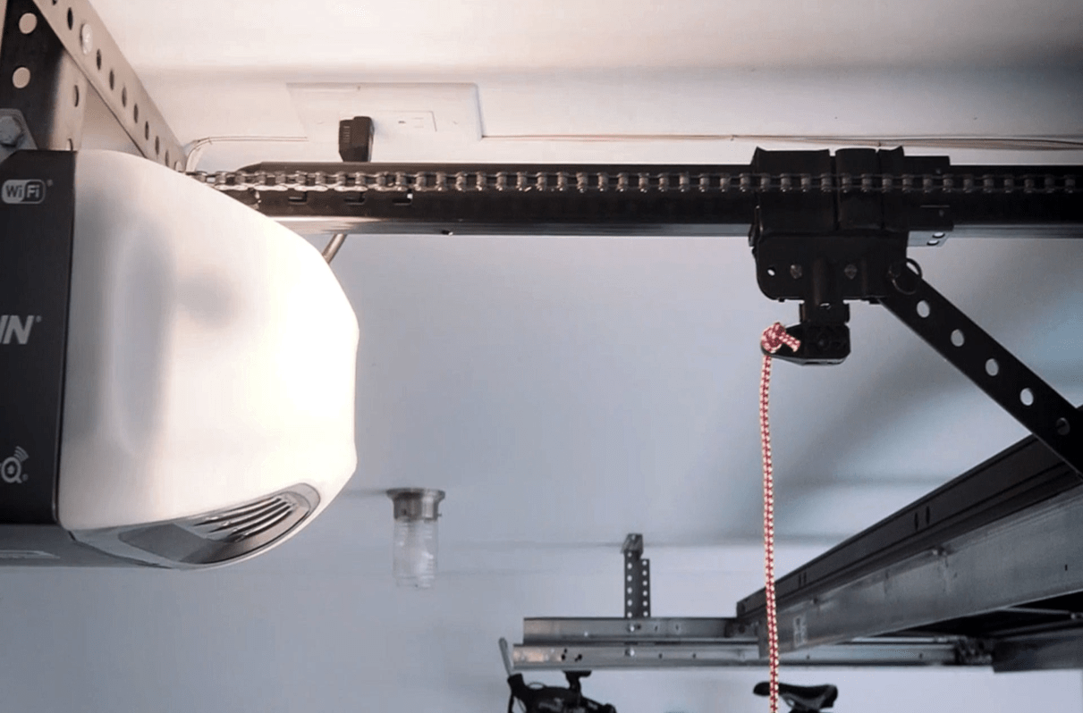 Garage door opener and tracks on ceiling of open residential garage