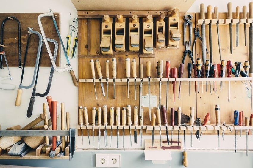Repair tools hanging on wall above workbench in garage workshop