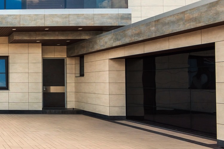 Black paneled garage door on home with tiled exterior