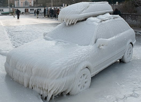 Snow-covered Suburu Explorer and rooftop kayak