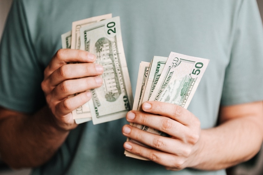 Man in Green Shirt Counting Money in Assorted Bills