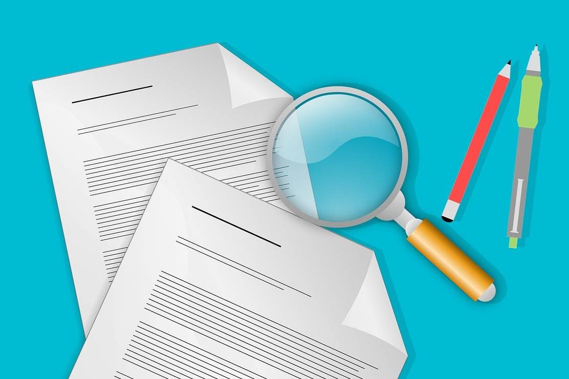 Animation of two documents with dog-eared corners beside magnifying glass and two pencils