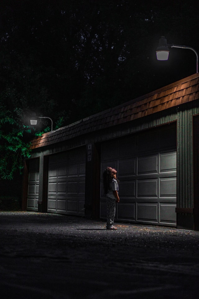 Toddler looking upward at top of stuck garage door