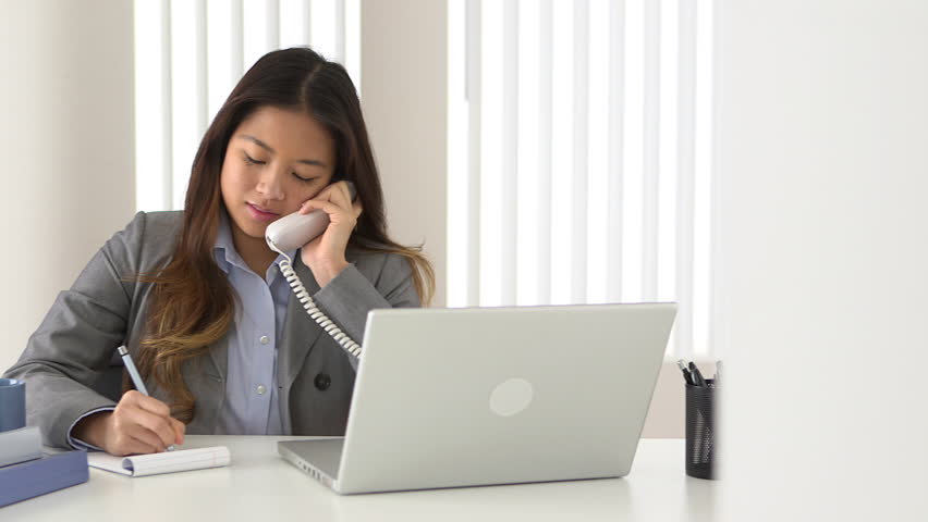 Woman Taking Notes During Phone Call