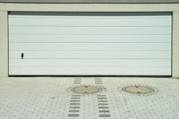 Two-car white paneled garage door and adjacent concrete driveway