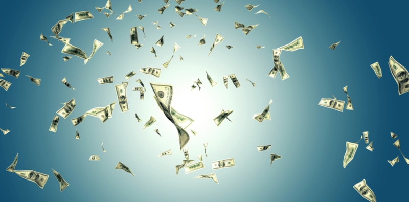 Money blowing in the wind against clear blue sky on sunny day