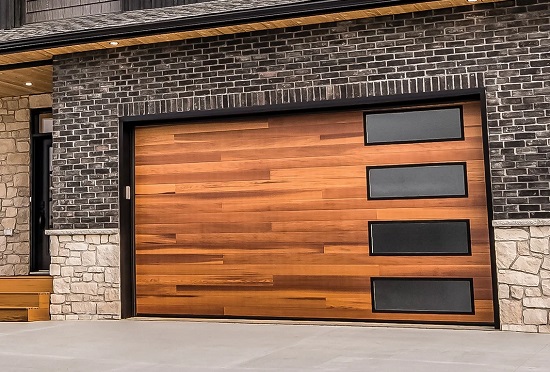 Plank-style two-car wood grain garage door with short panel tinted windows on residential garage
