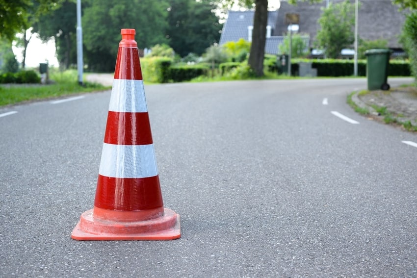 Red and White-Striped Warning Cone in Middle of Road