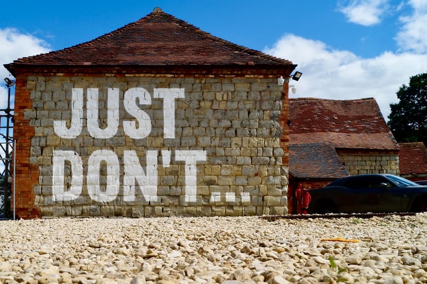 Brick Garage Exterior Painted with Warning Message 'Just Don't...