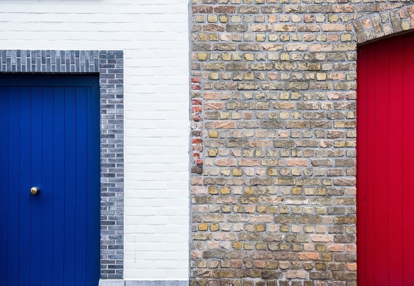 Brightly colored red and blue garage doors of adjacent Denver-area homes