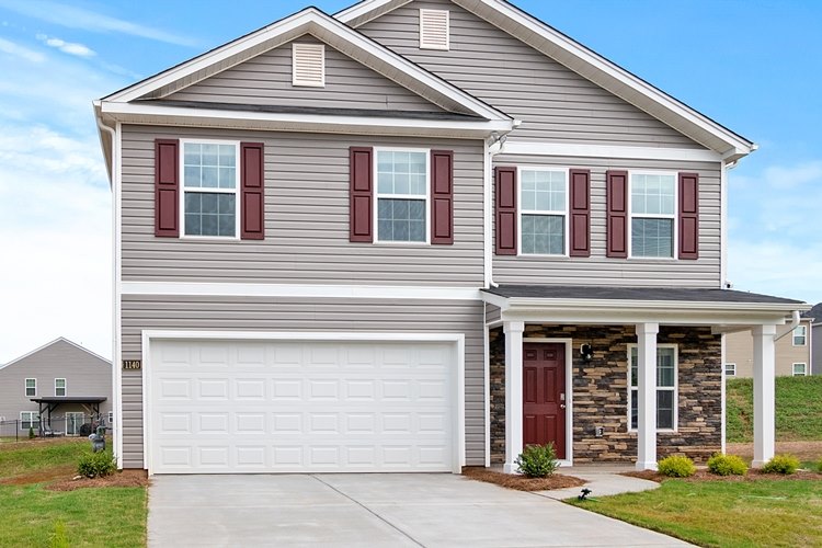 Two story house with gray siding and white two-car paneled garage door