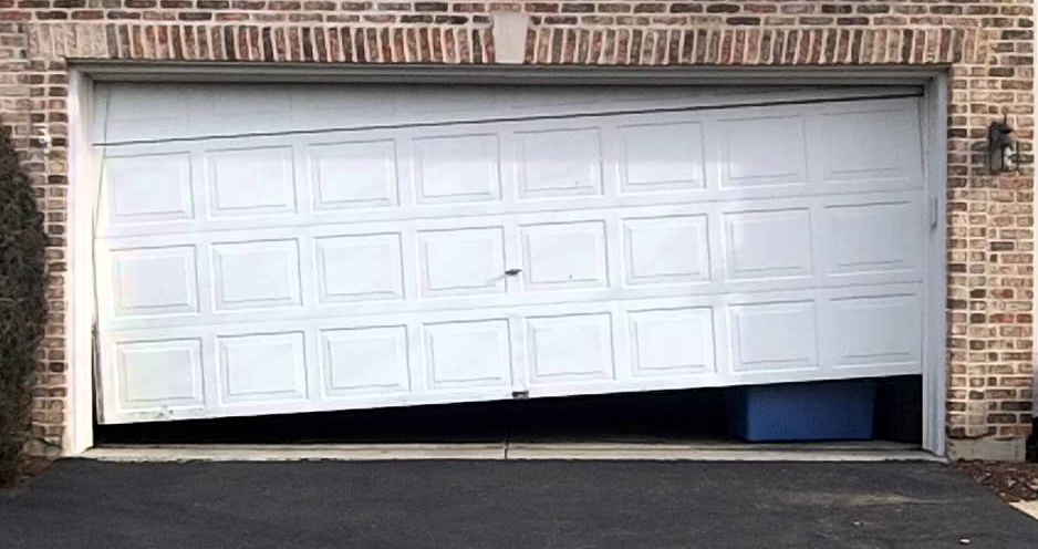 Crooked white two-car garage door partially closed