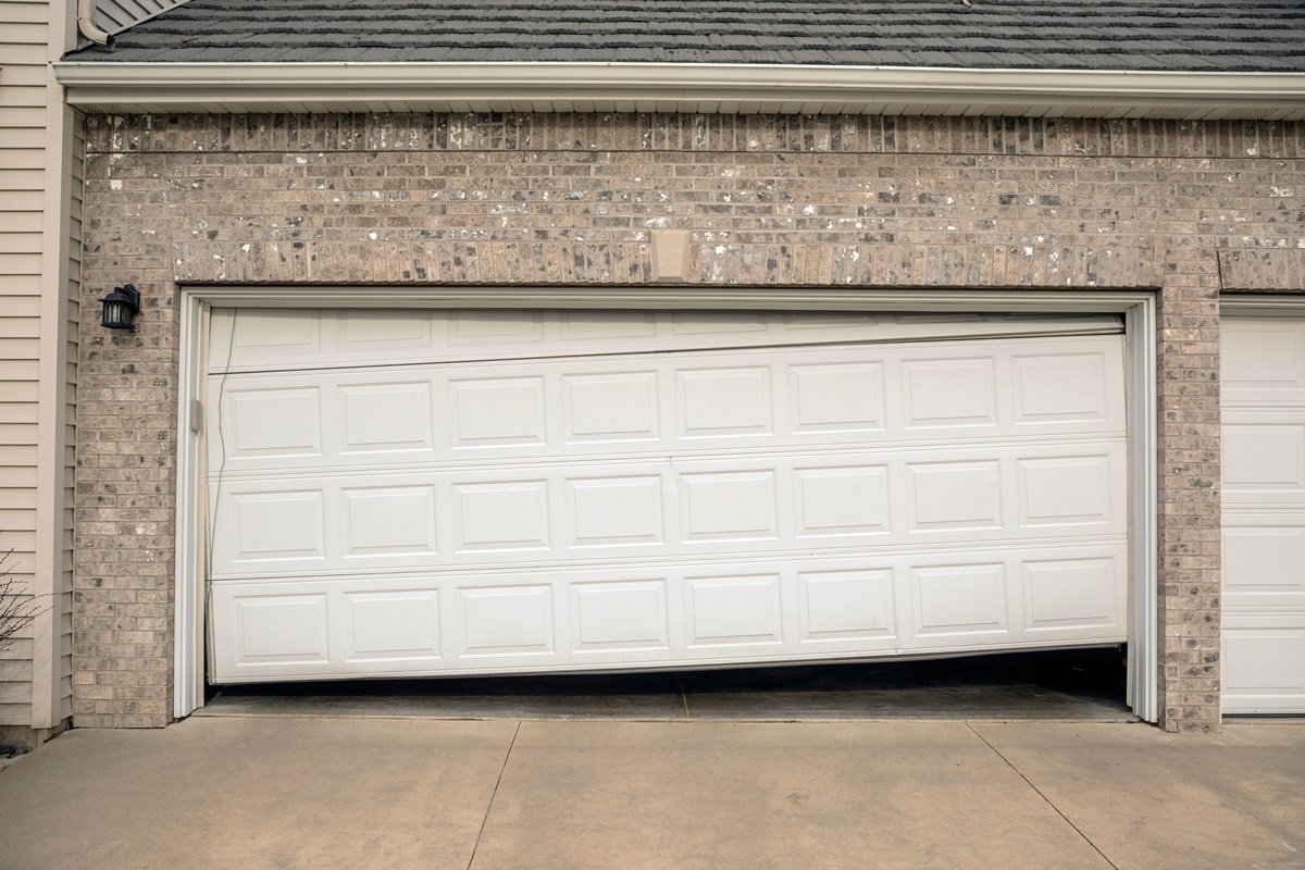 Two-car residential garage with misaligned white garage door