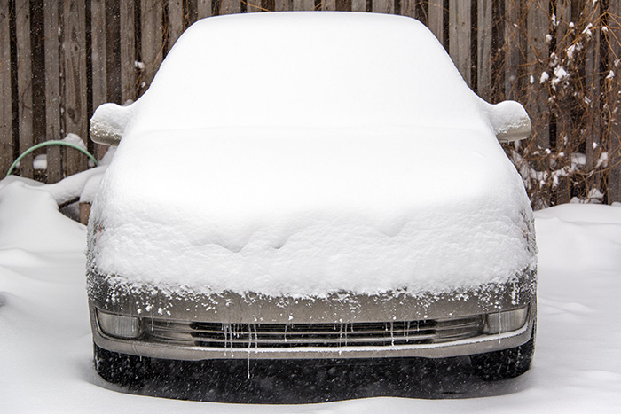 White sedan covered in snow