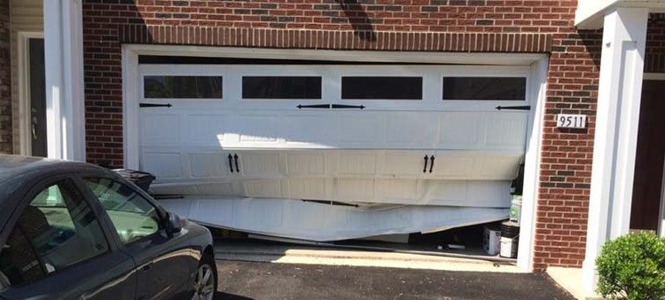Damaged overhead garage door and black car after accident