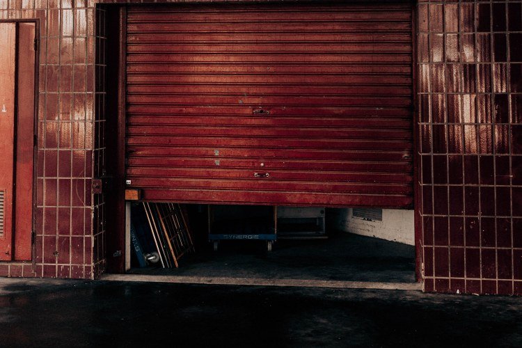 Red steel garage door stuck partially open