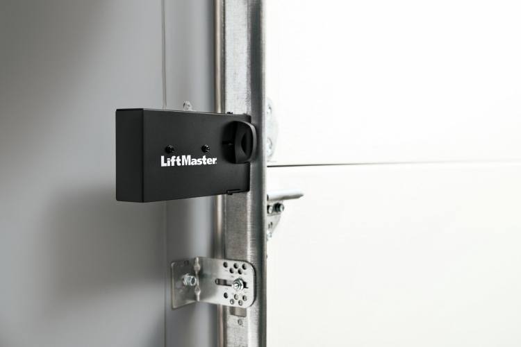 Liftmaster brand garage door lock attached to white garage door's tracks